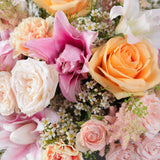 Close-up of a bouquet of colorful flowers including roses and lilies.